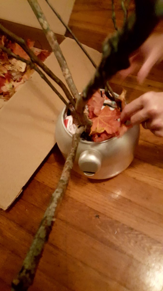 Arrange leaves around the branches to cover the paper.