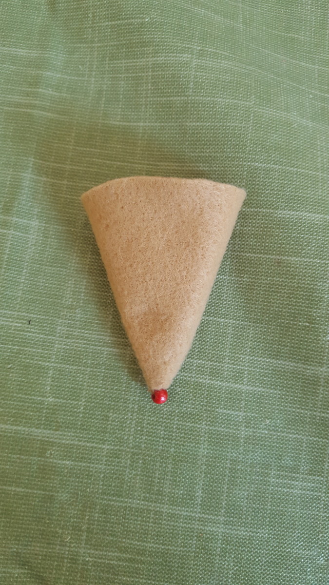 Sew the bead on the tip of the cone to create the mouse's nose.