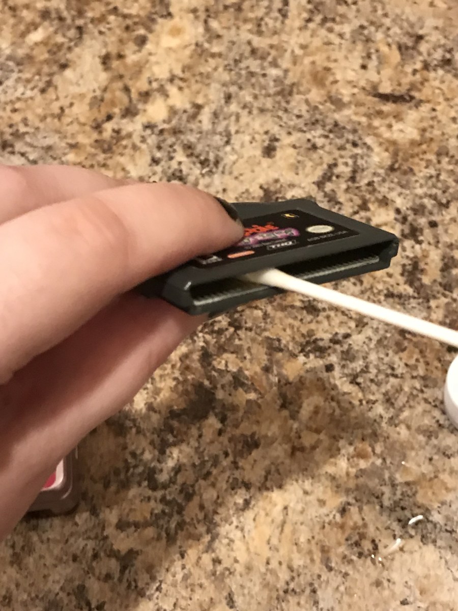 Gently rub the cotton swab against the game's connectors in an up and down motion (never go side to side).