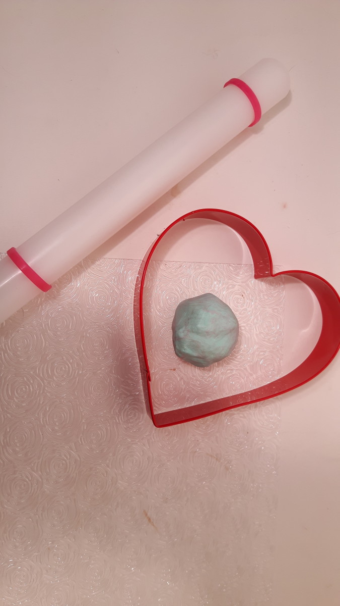 You'll need clay, a rolling pin, and a heart-shaped cookie cutter.