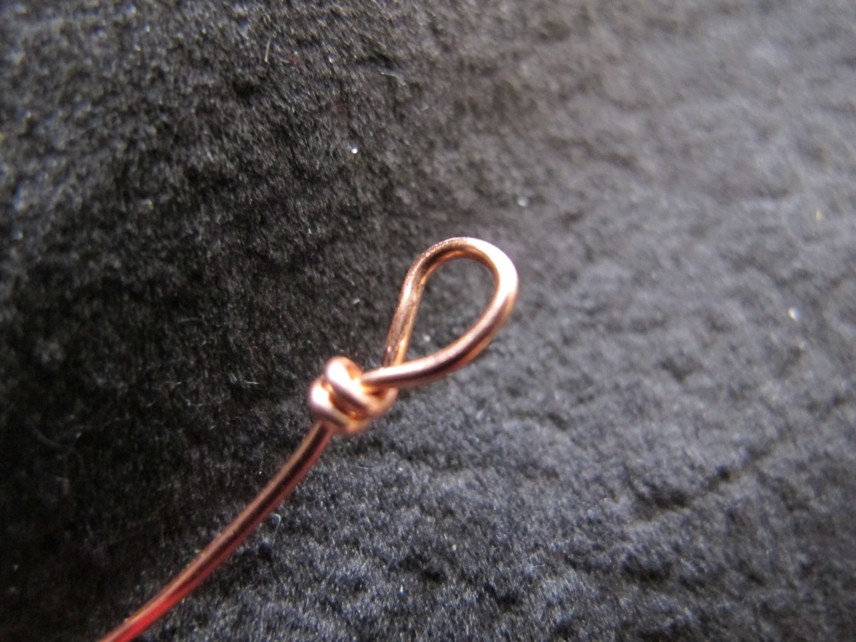 Wrap the "tail" around the wire and below the loop, forming a secure bail for the pendant.