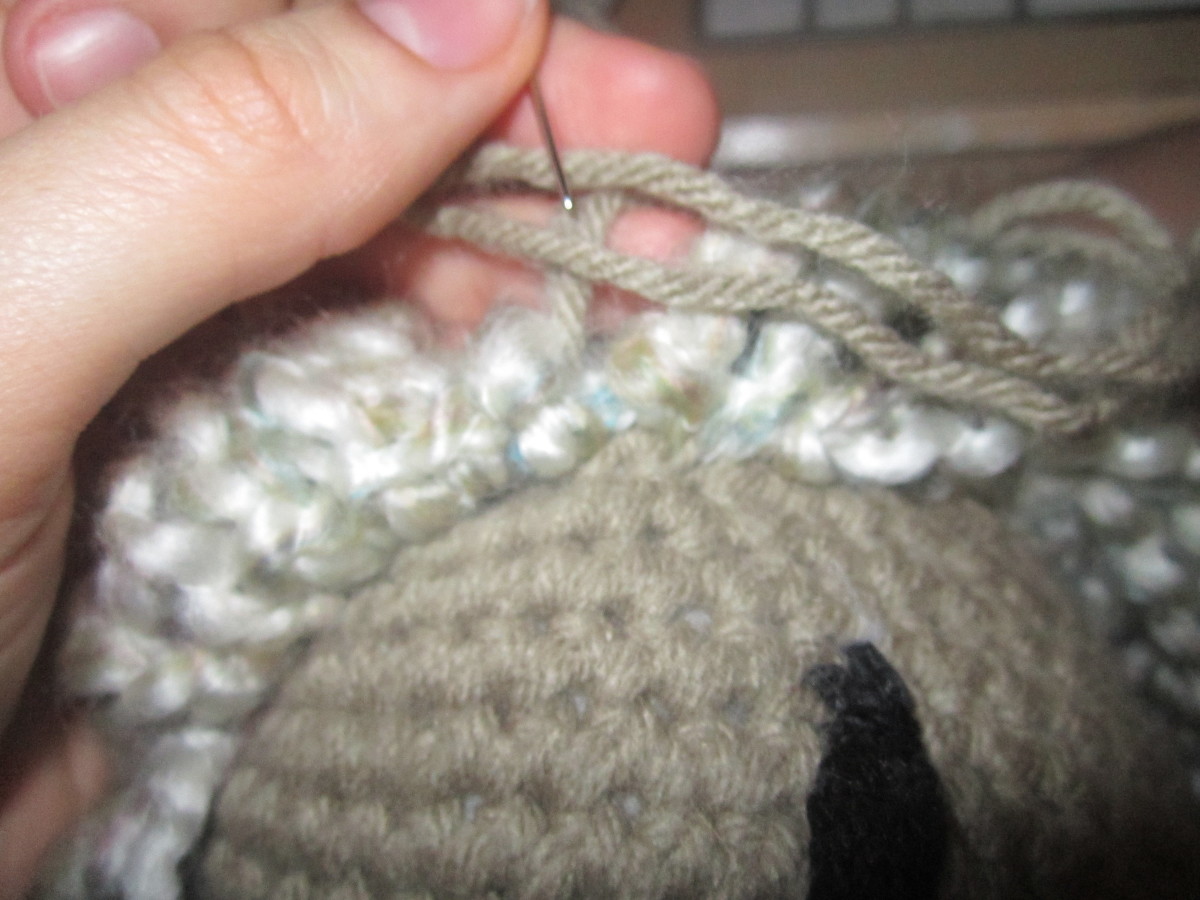 When you're happy with your wig sew it on using skin tone coloured yarn. Work along the edges so it blends in better, giving it more of the effect of hair growing out of the head. When you're happy with your wig sew it on using skin tone coloured yarn. Work along the edges so it blends in better, giving it more of the effect of hair growing out of the head.
