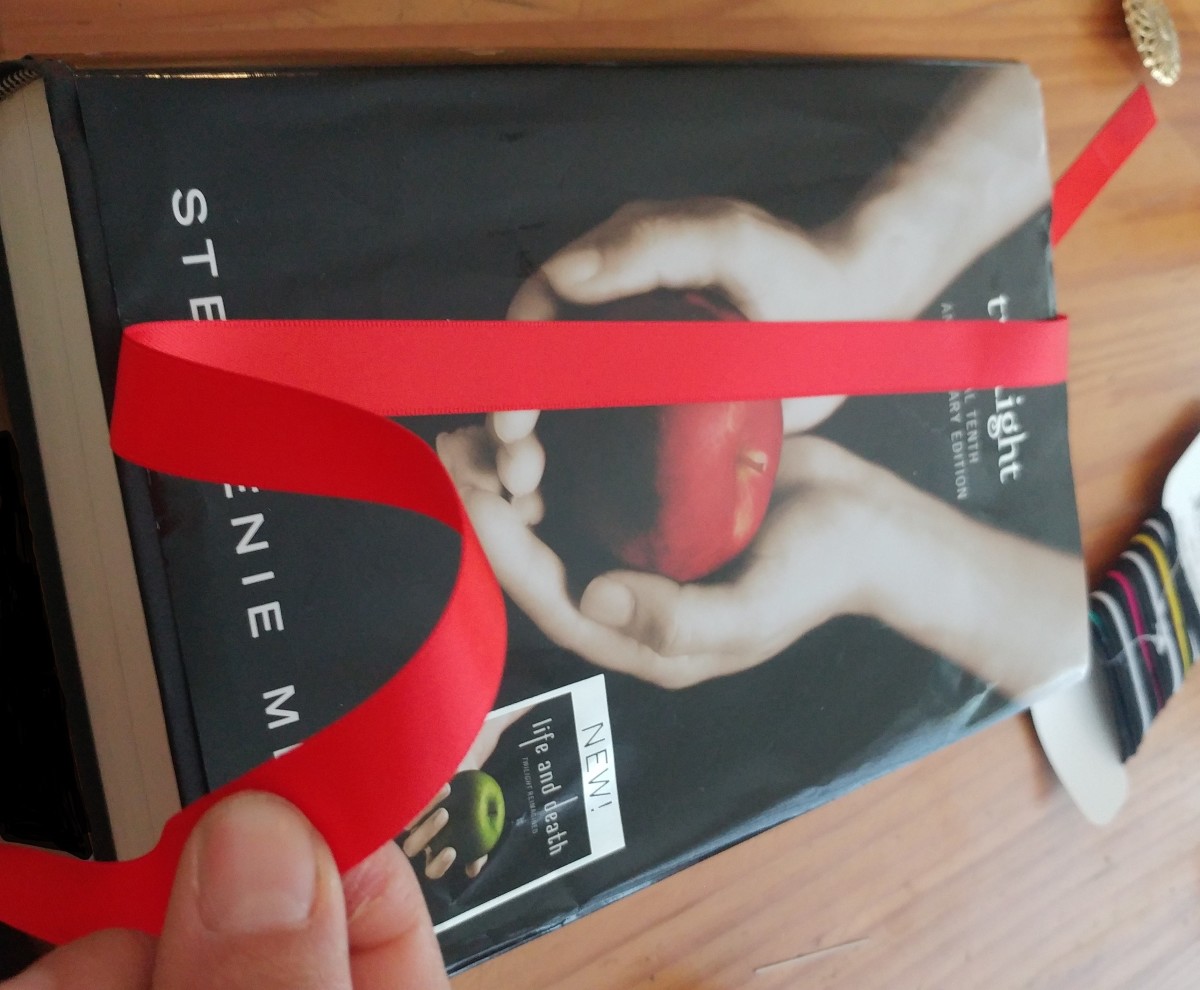 Measure the red ribbon twice the length of the cover, of the novel of your choice.