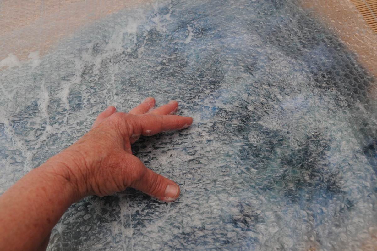 Rubbing the wet surface of the bubble wrap.