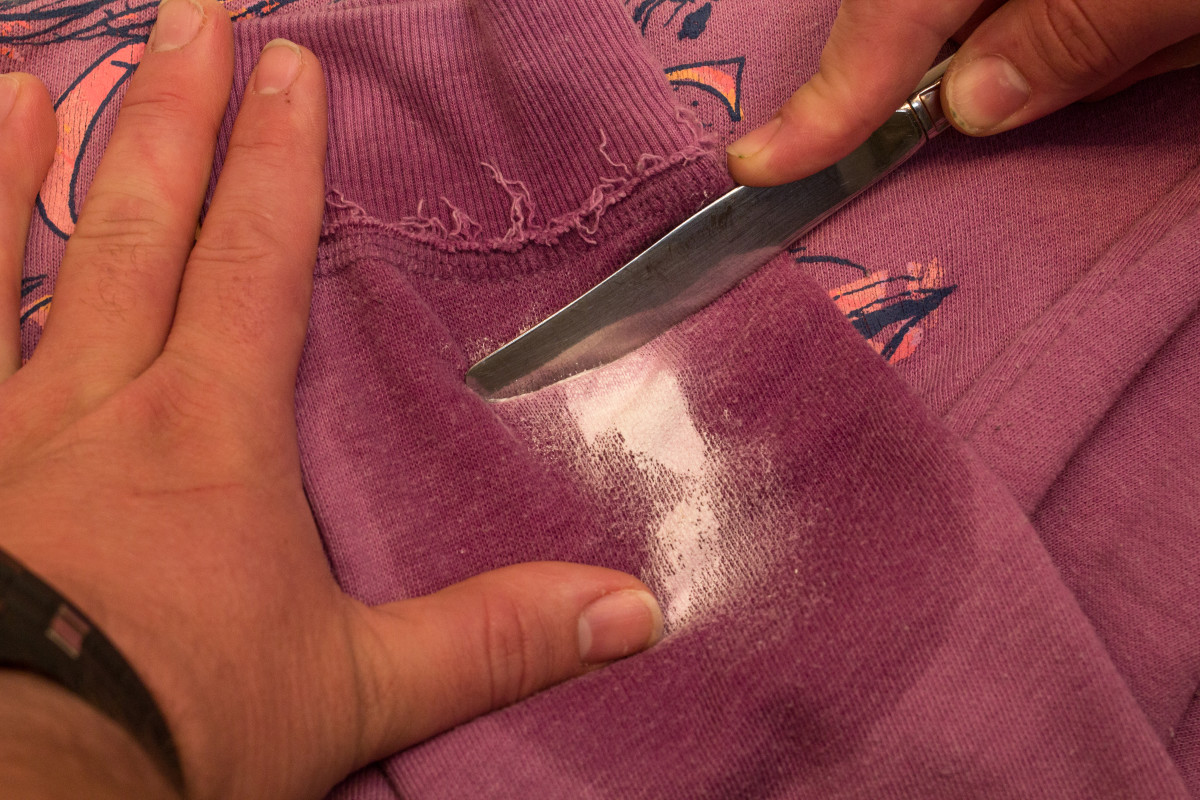 Scrape the paint off of the clothing.