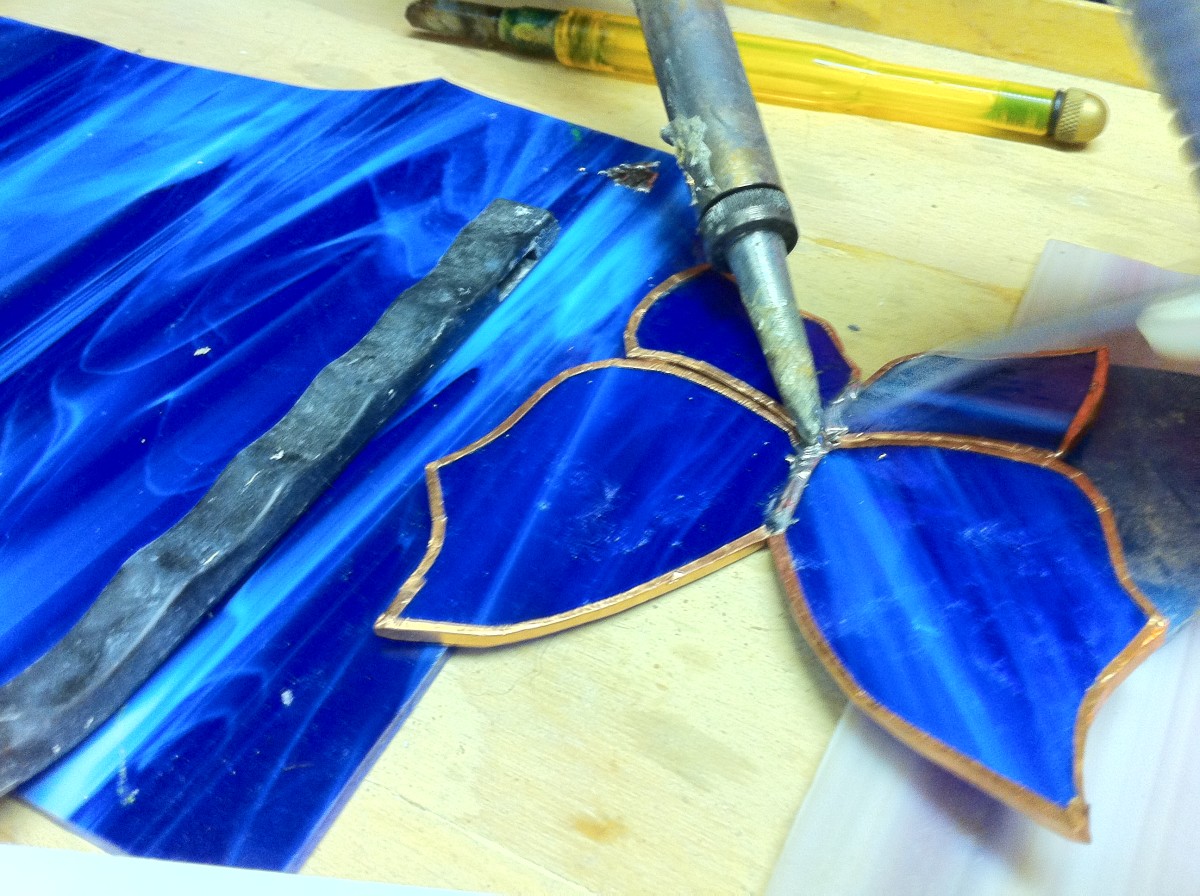 Soldering all four pieces of the glass together to make the butterfly.