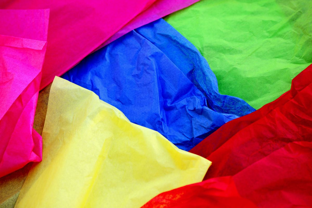 Crumpled colorful tissue paper on a blue tissue paper background