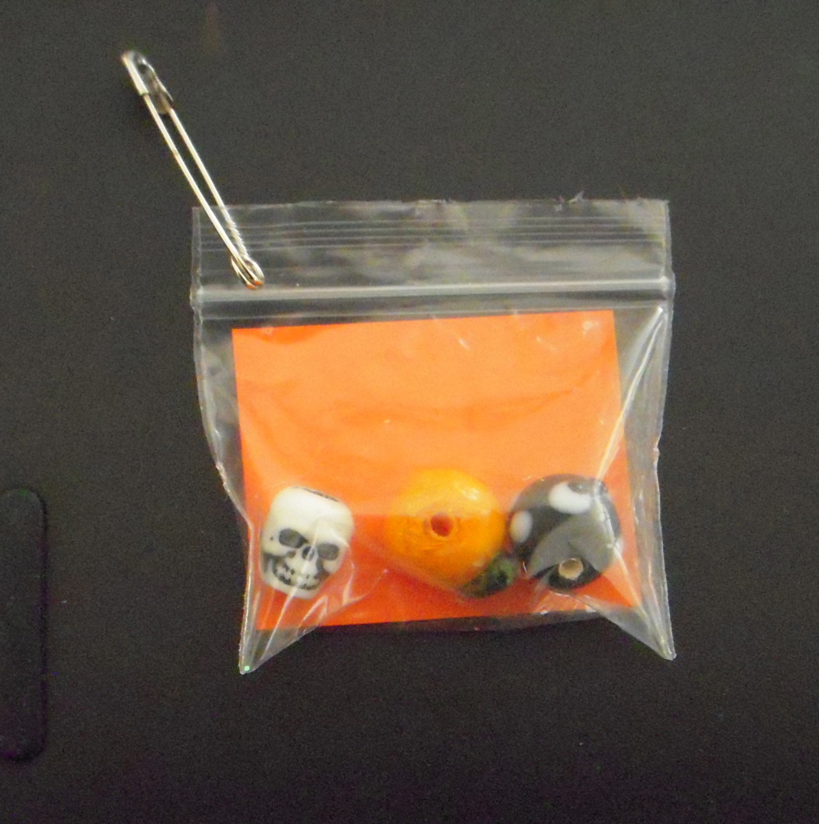 This is an easy SWAP that uses bulk halloween themed beads: a skull, a pumpkin and a black cat. The orange card reads "Halloween in a Bag" and has the girl's name and troop number on back.