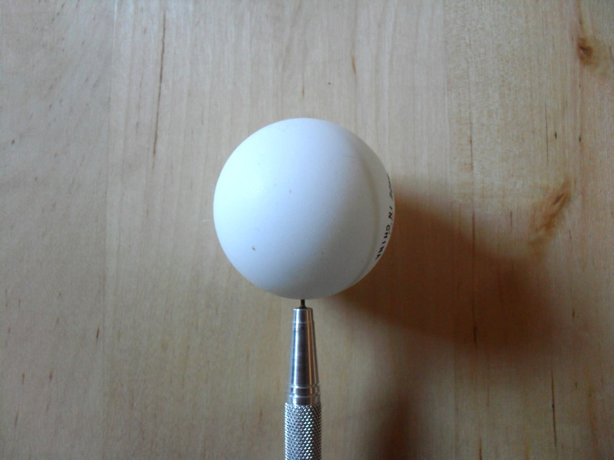 Pierce the ping pong ball with a sharp object.