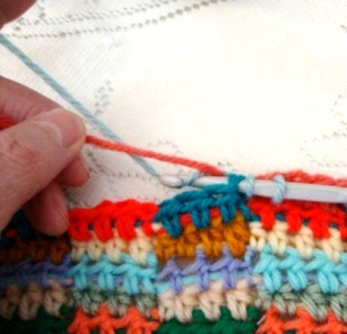 Pull yarn under carried color and pull back through first HDC.