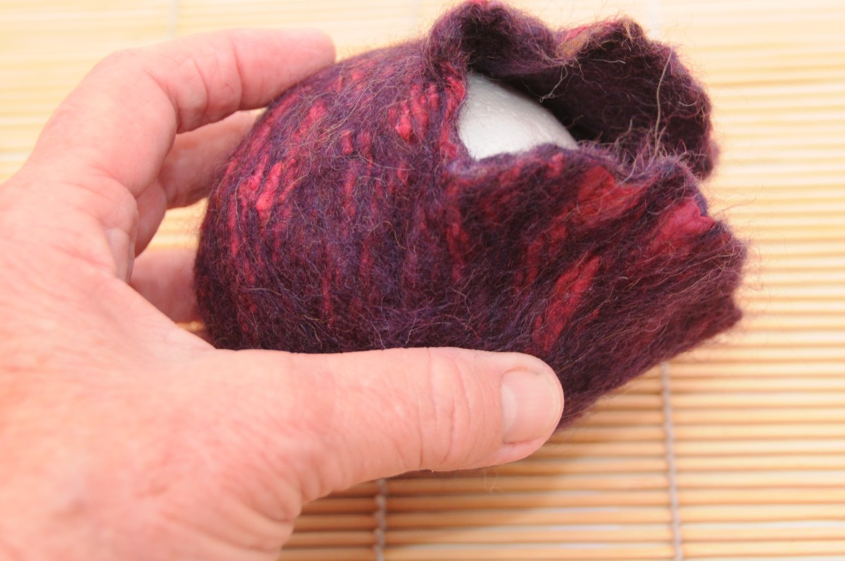 A fully fulled purse with the small polystyrene ball placed inside.  This purse was nuno felted with silk on the decorative layer.