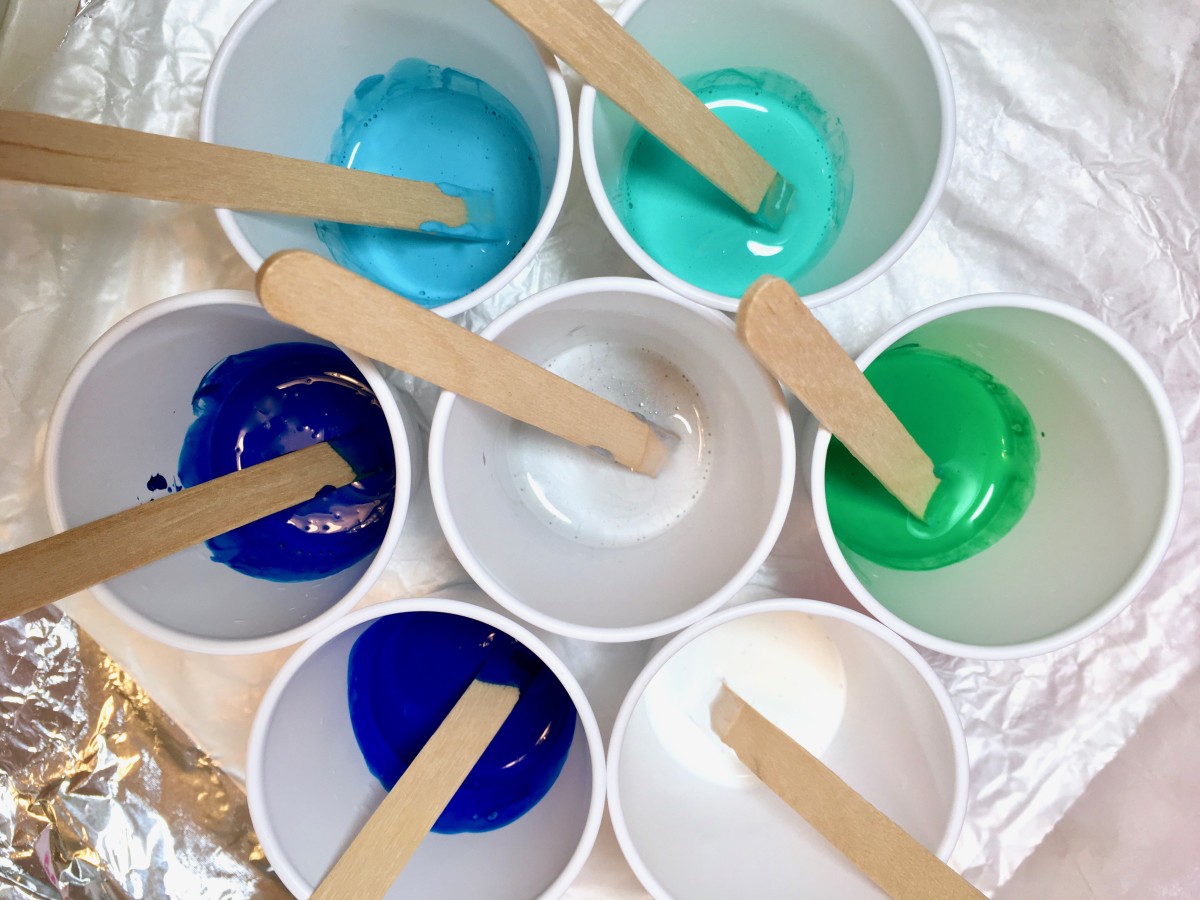 Plastic cups filled with pouring medium and paint.