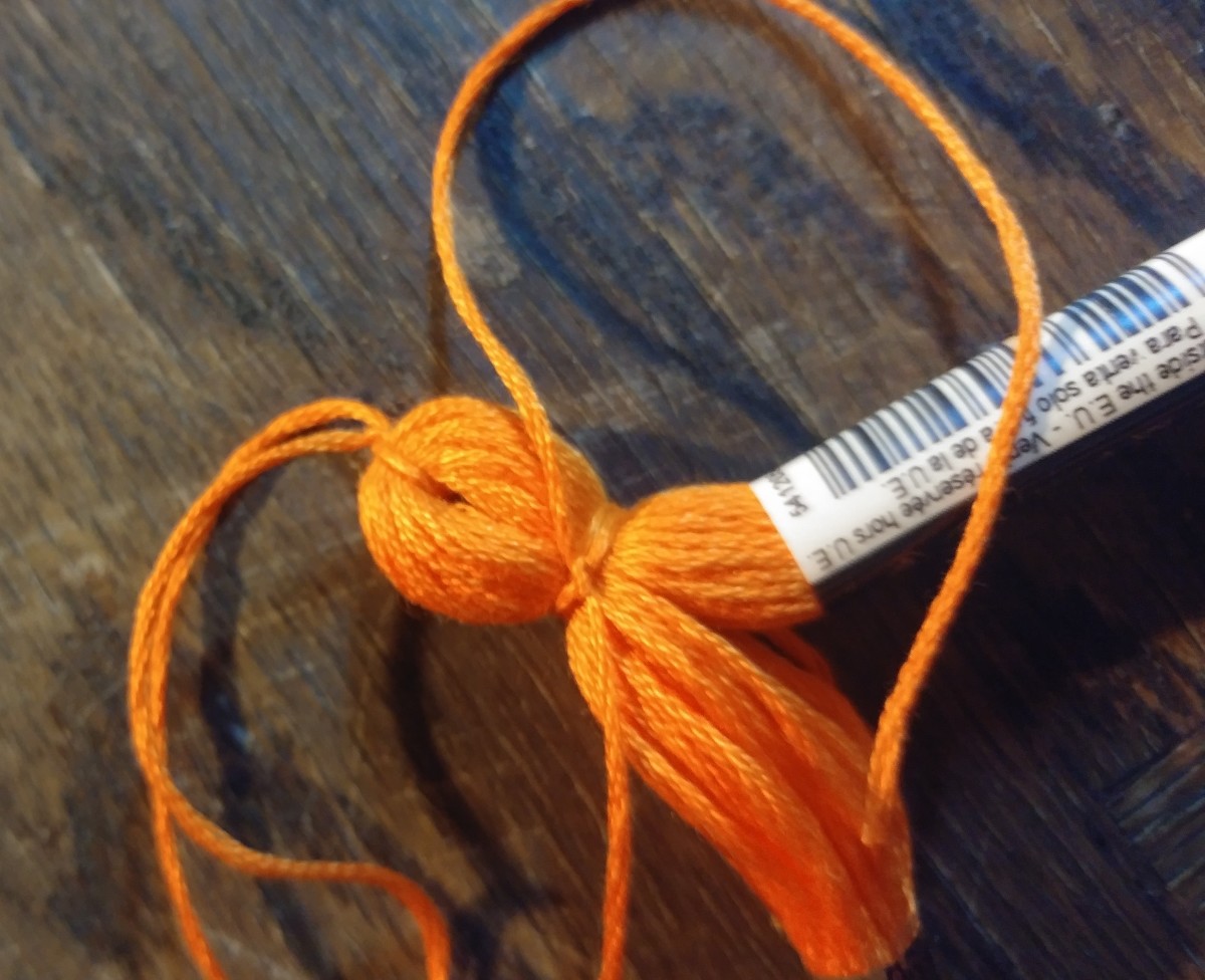 Tie long thred near the top of tassel, into a tight knot.