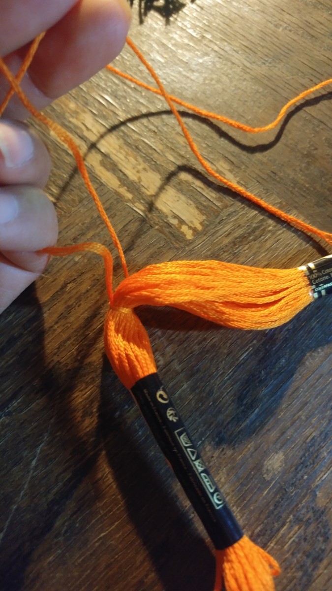 Be sure to tie piece of thread evenly down the middle of threads.