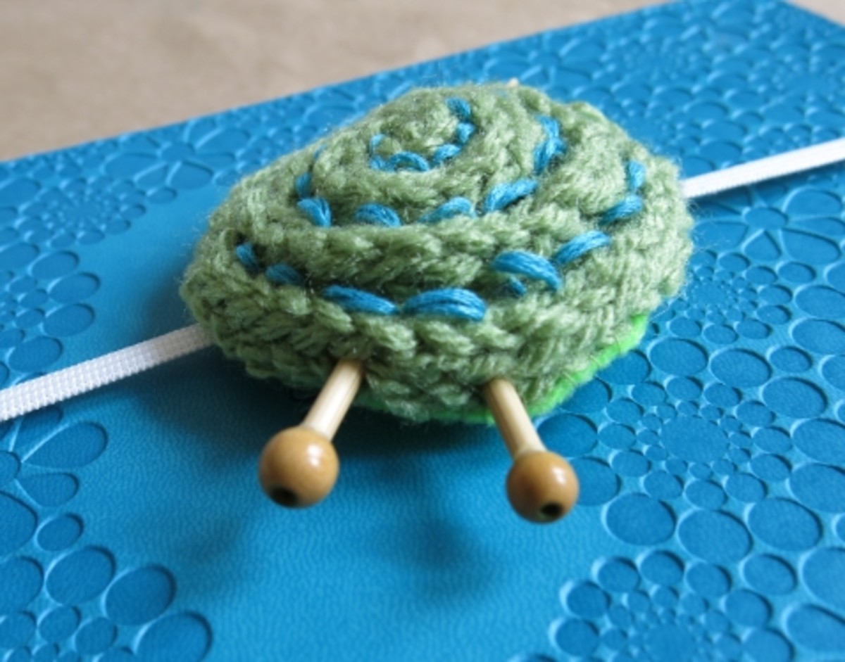 Slide each needle into the side of your i-cord and through your yarn ball to the other side.