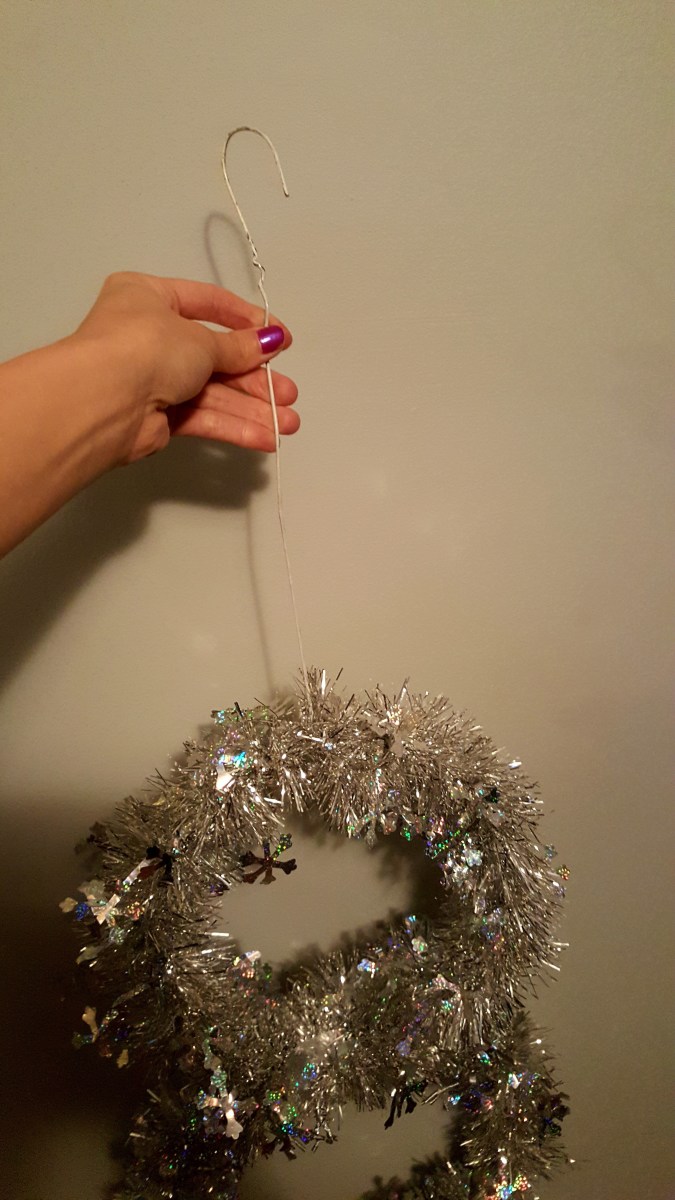 Use any left over wire hanger pieces to create a hook. Or create a hook using your floral wire. Attach to the middle of your top circle to hang your snowman. 