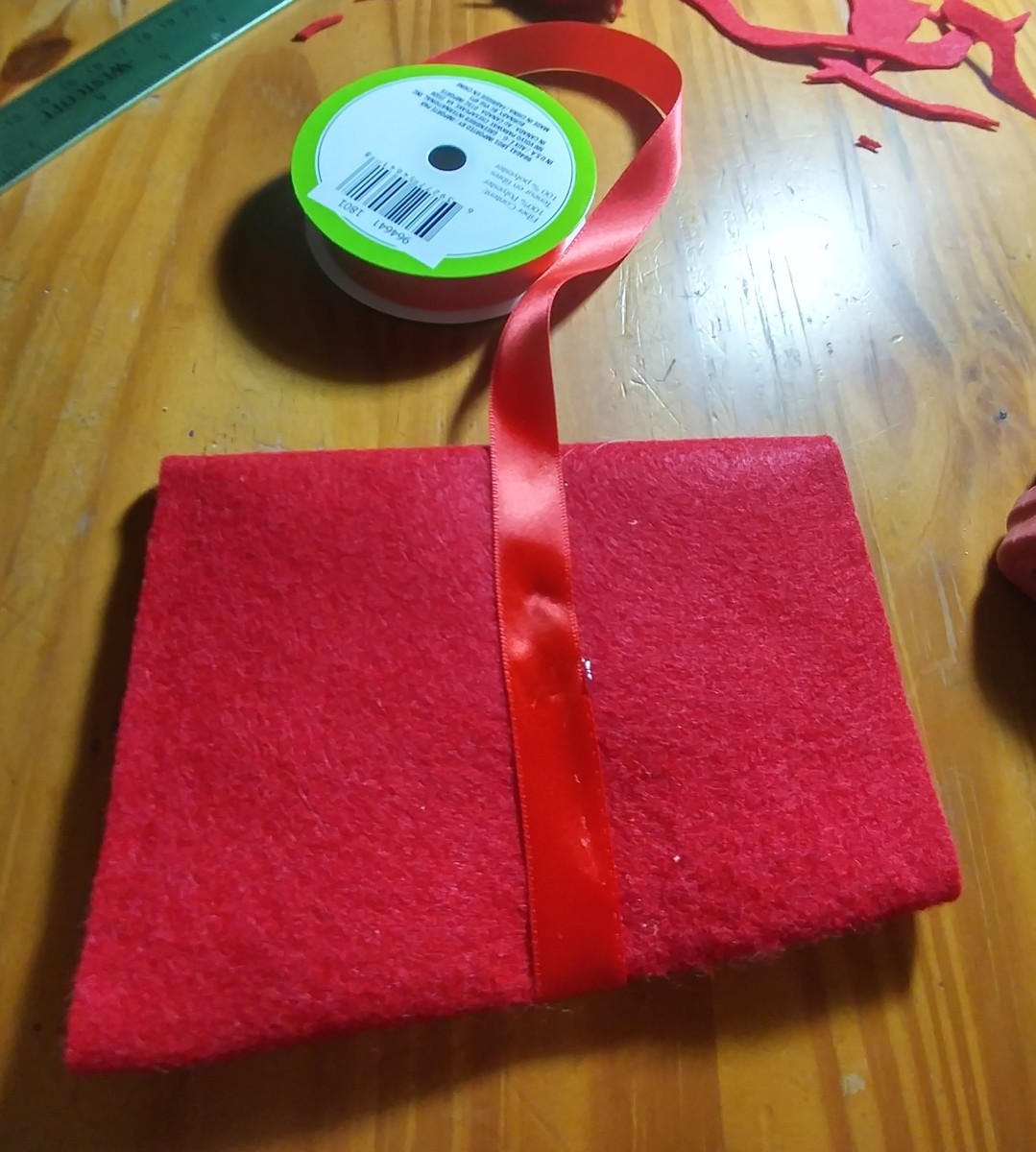 Glue ribbon onto the back as well. Run ribbon to the front of the bottom half of envelope and glue.