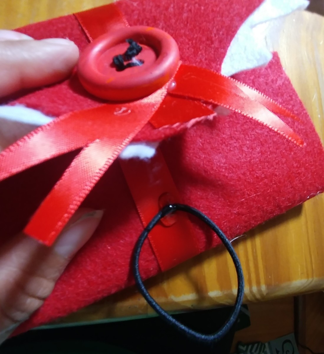 Glue black hair tie onto the bottom flap, so that the envelope can be closed.
