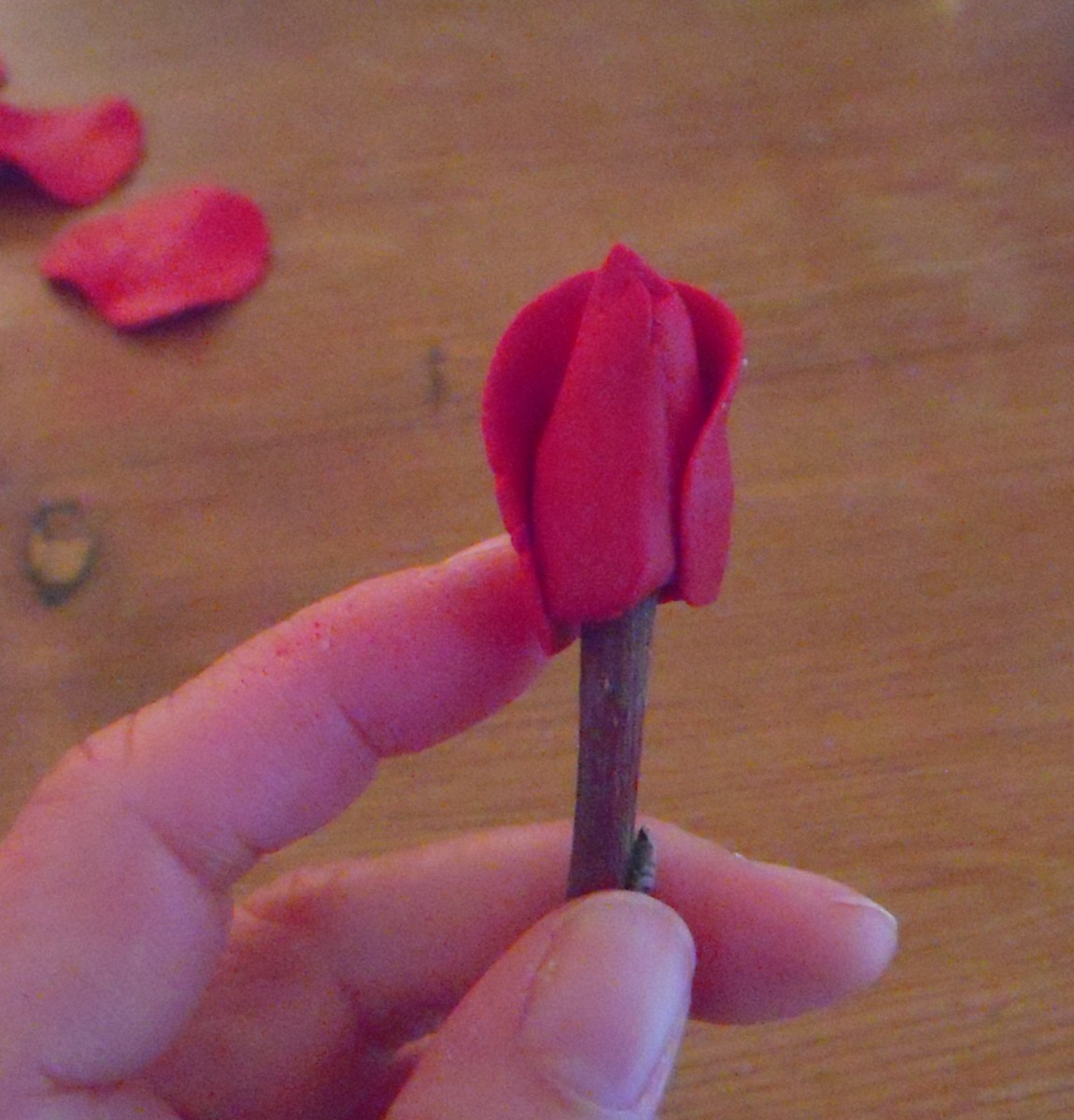 Wrap first petal around rose hip. Leave top unattached, but press petal to base securely.
