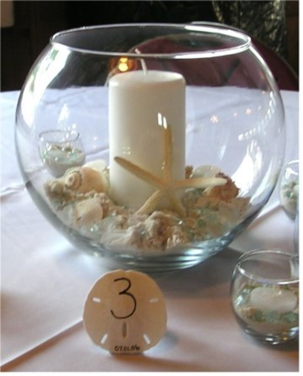 A simple but elegant beach wedding candle and shell centerpiece.