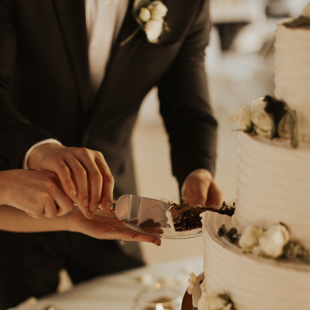 At many receptions, the newlywed couple cut their wedding cake hand-in-hand before it is served to the guests. 