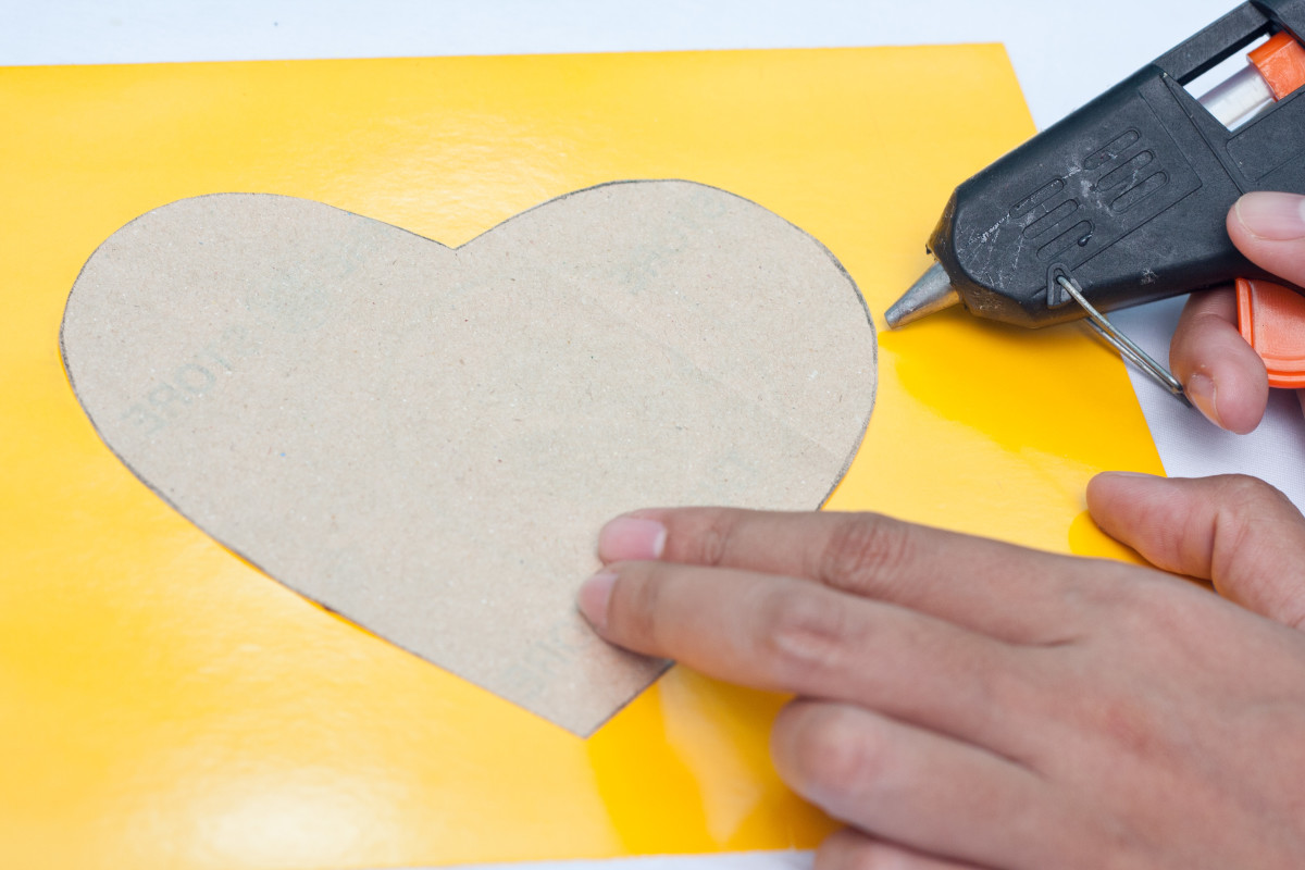 Step 4: Using hot glue, glue the heart shaped pattern onto the middle of your thick piece of cardboard. Set it aside so it can dry and continue with the next steps of your project.