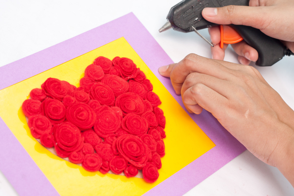 Step 10: Glue your frame in place around the outside of your rose filled heart. Using hot glue, glue the border or frame to the piece of cardboard with the roses on it.