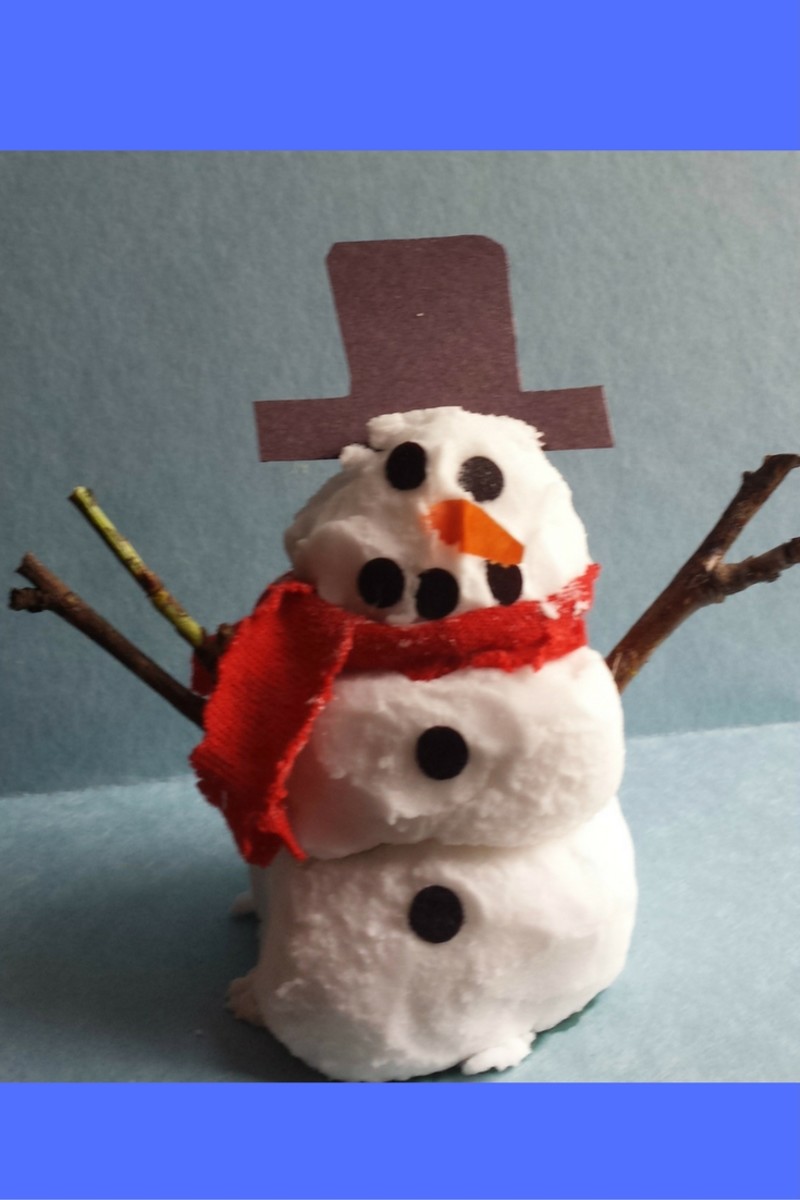 A closeup of our Frosty we made with DIY snow. He stands 4 1/2 inches tall. We used construction paper to make his hat, buttons, mouth, and nose. We used twigs for his arms. For his scarf, we used a piece of red felt. Isn't he cute?