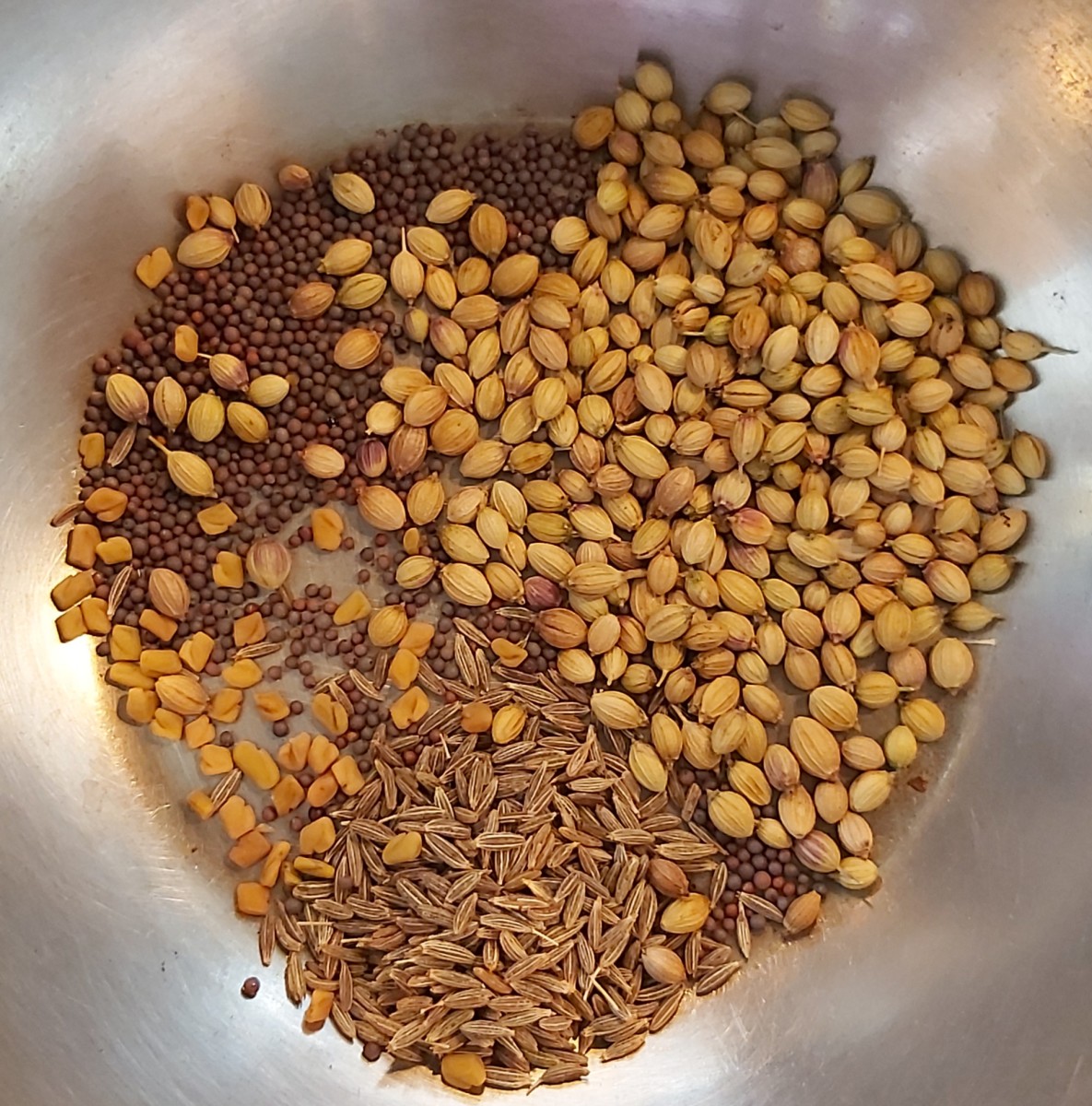 In a frying pan, add 1/2 teaspoon mustard seeds, 1 teaspoon cumin seeds, 2 teaspoon coriander seeds and 1/4 teaspoon fenugreek seeds.