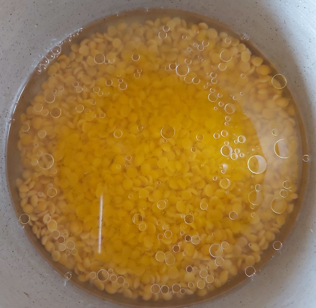 Add enough water to cook the lentils, then add 1/2 teaspoon of turmeric powder and 1 teaspoon of coconut oil (or ghee).