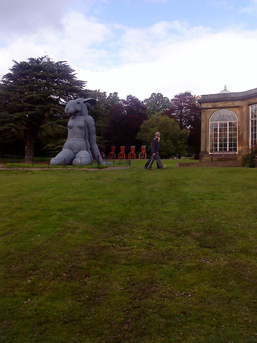 A giant hare-woman relaxing on the grass.