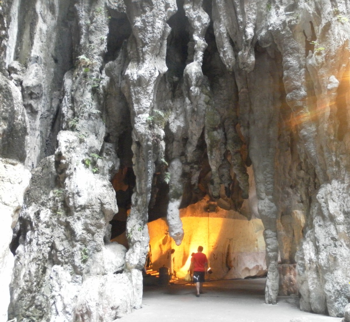 Rock formations inside Batu Caves. A small shrine stands in the lighted corner.