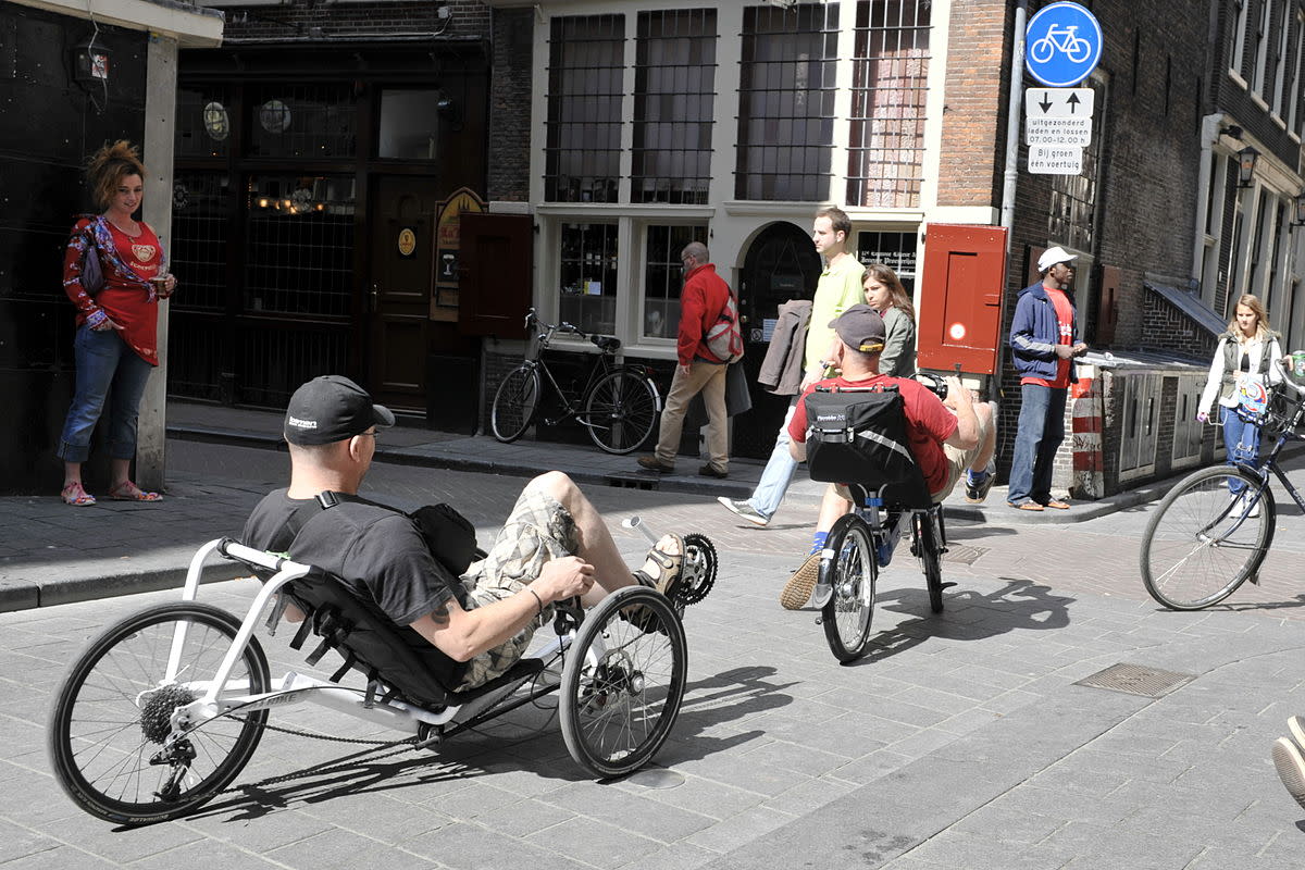 A cyclist totally relaxed in the red light district.
