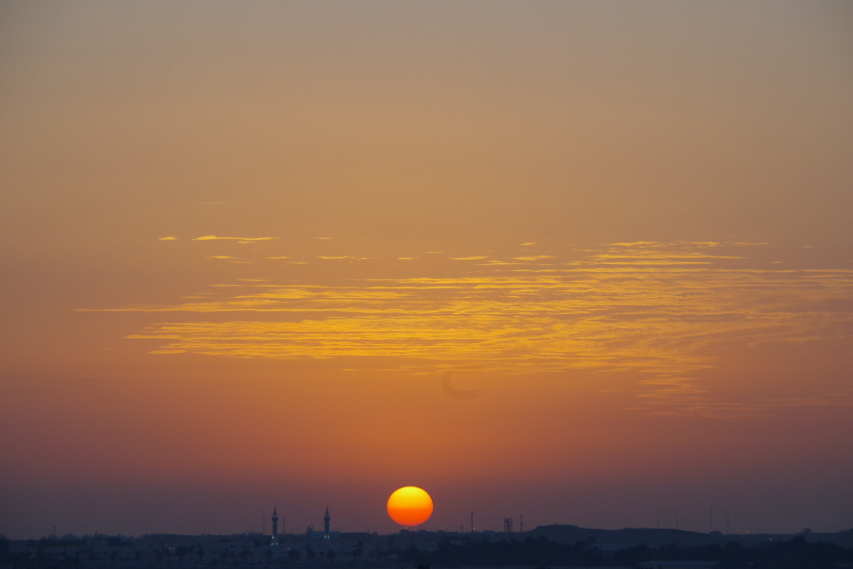 Sun setting behind a distant mosque (January 2016).