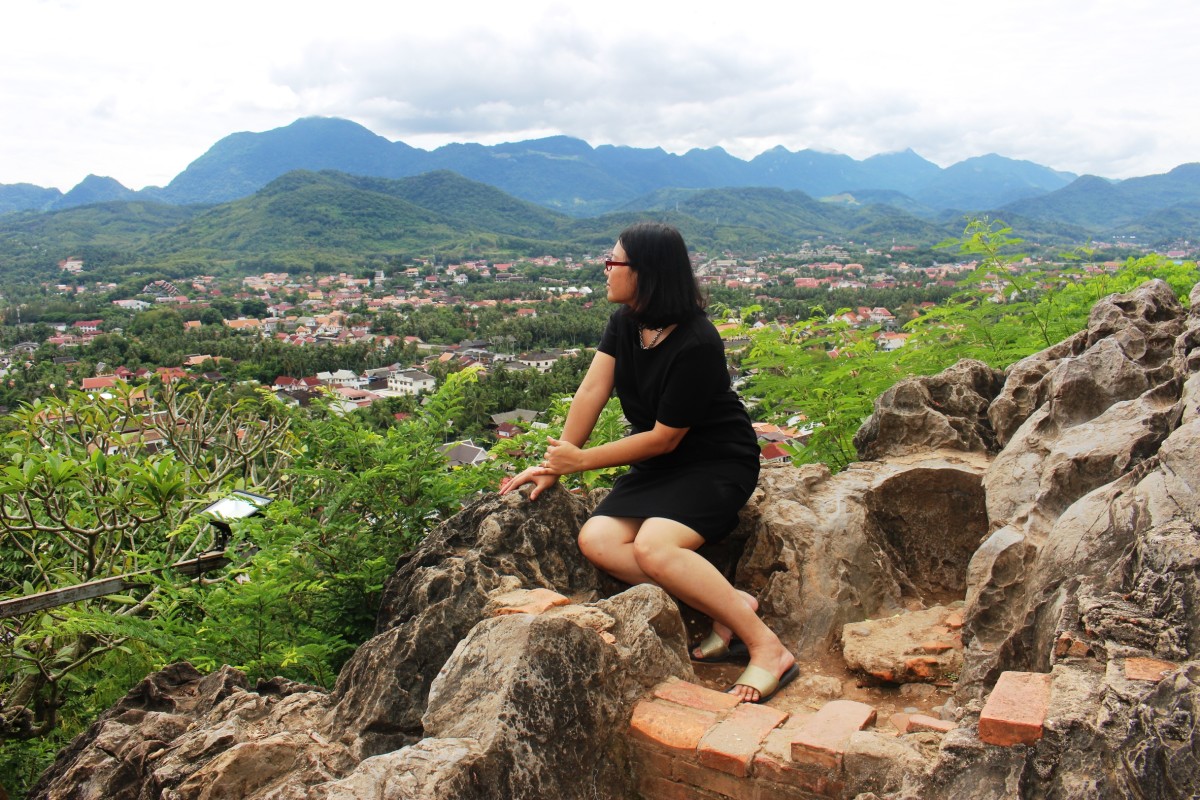 A tourist looks at the view of the town on Mount Phu Si.