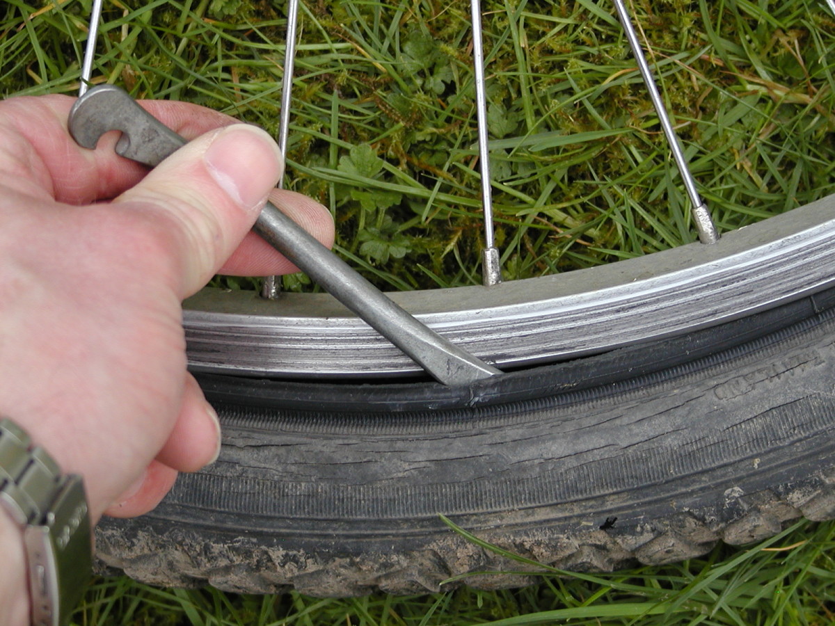 Use the blunt end of the tire lever to lever the bead of the tire out from the rim