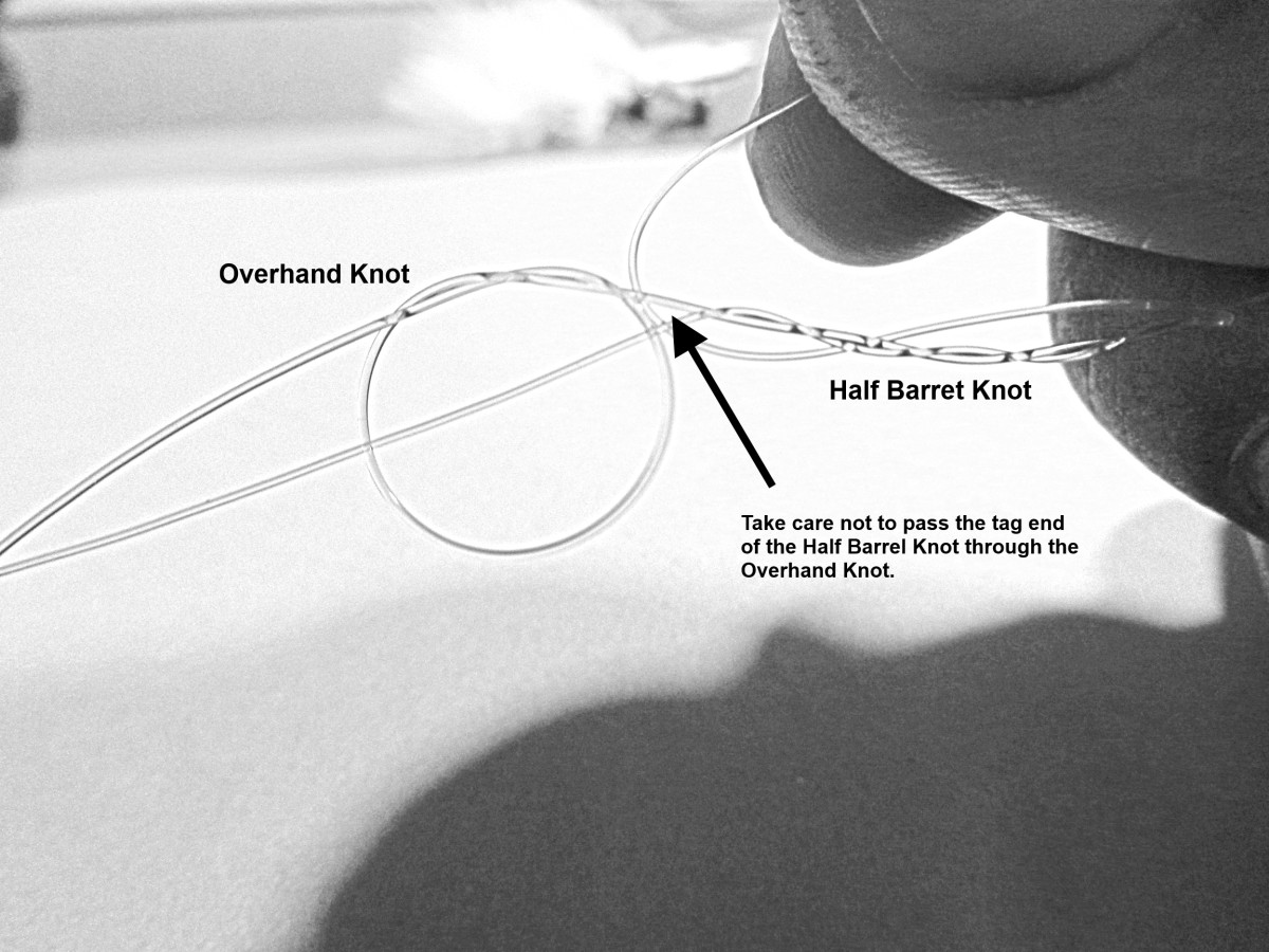 Half Barrel Knot being tied using the Dropper Line, taking care not to pass the tag end through the Overhand Knot