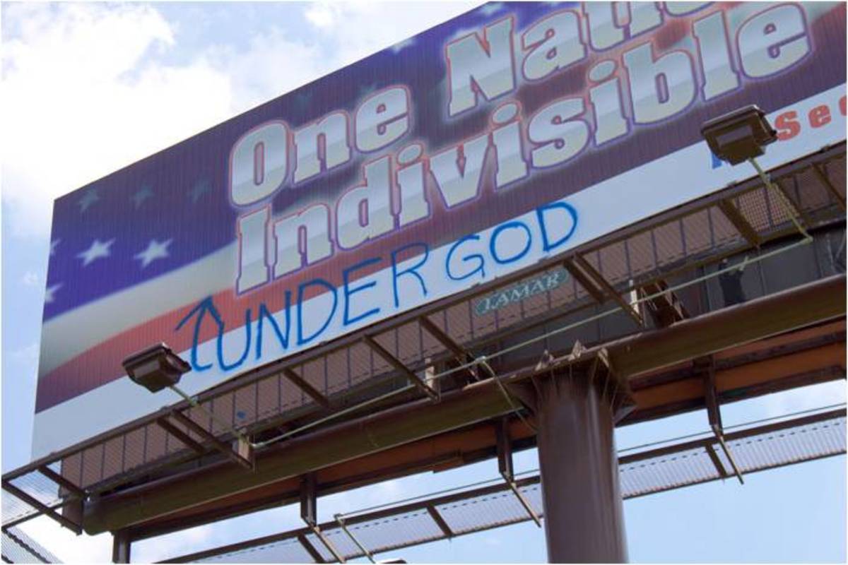 The billboard proclaiming "One Nation Indivisible" is edited with graffiti.