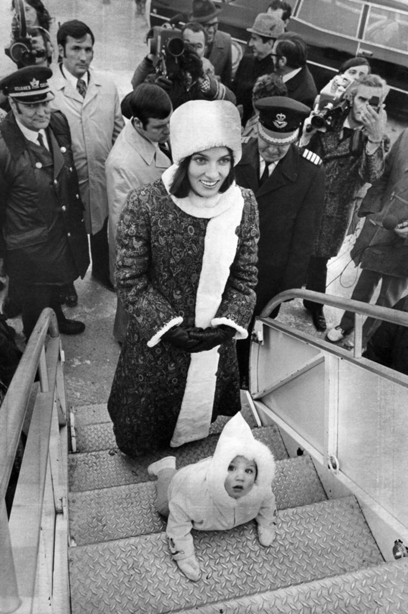 11-month-old Justin Trudeau, urged on by his mother Margaret Trudeau, crawls up the steps of an aircraft in Ottawa to meet his father on his return from Britain (Dec 5, 1972) .