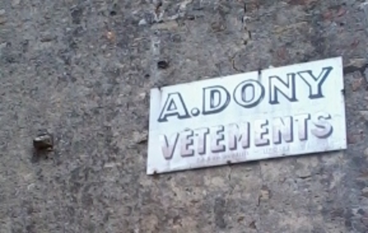 An old shop sign on the side of a building.