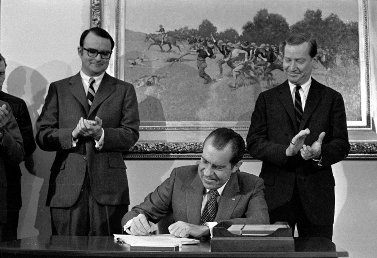 Nixon signing the Clean Air Act of 1970 with Russell Train and William Ruckelshaus looking on