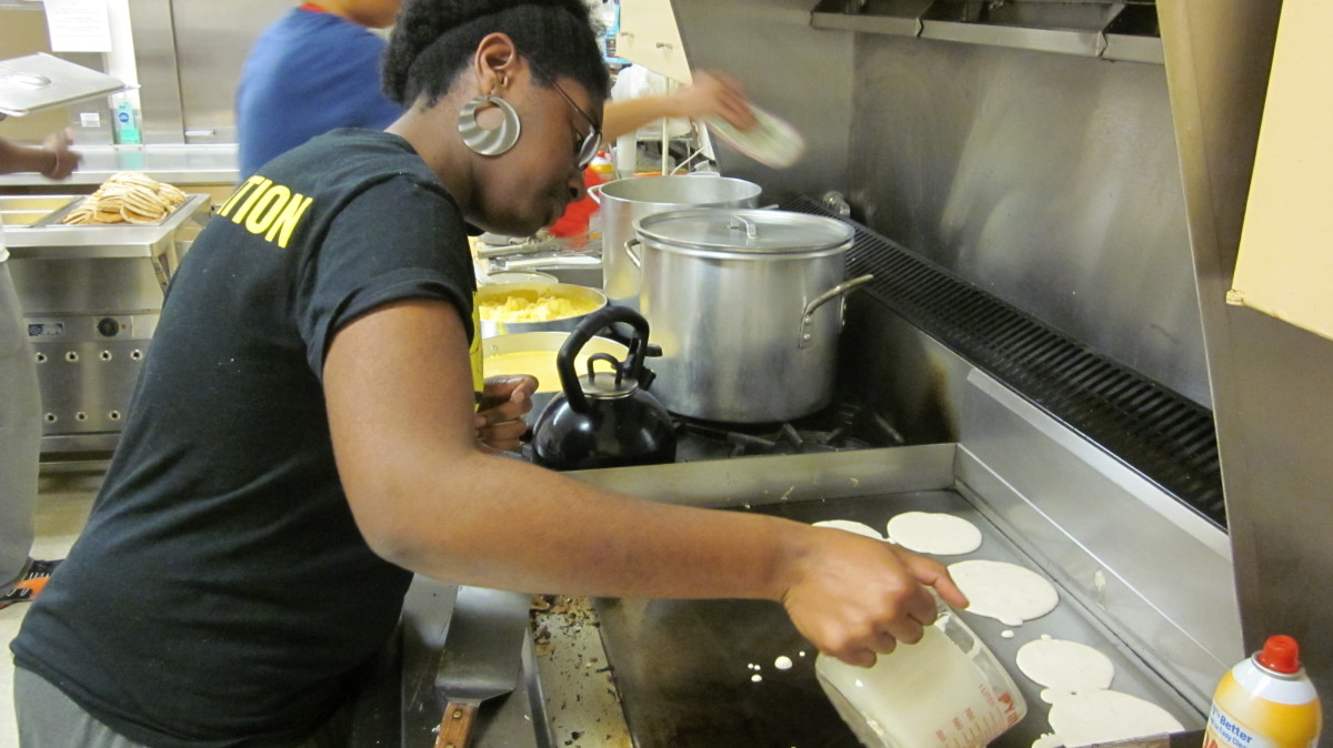Volunteer makes pancakes for bi-weekly breakfast program for the needy.