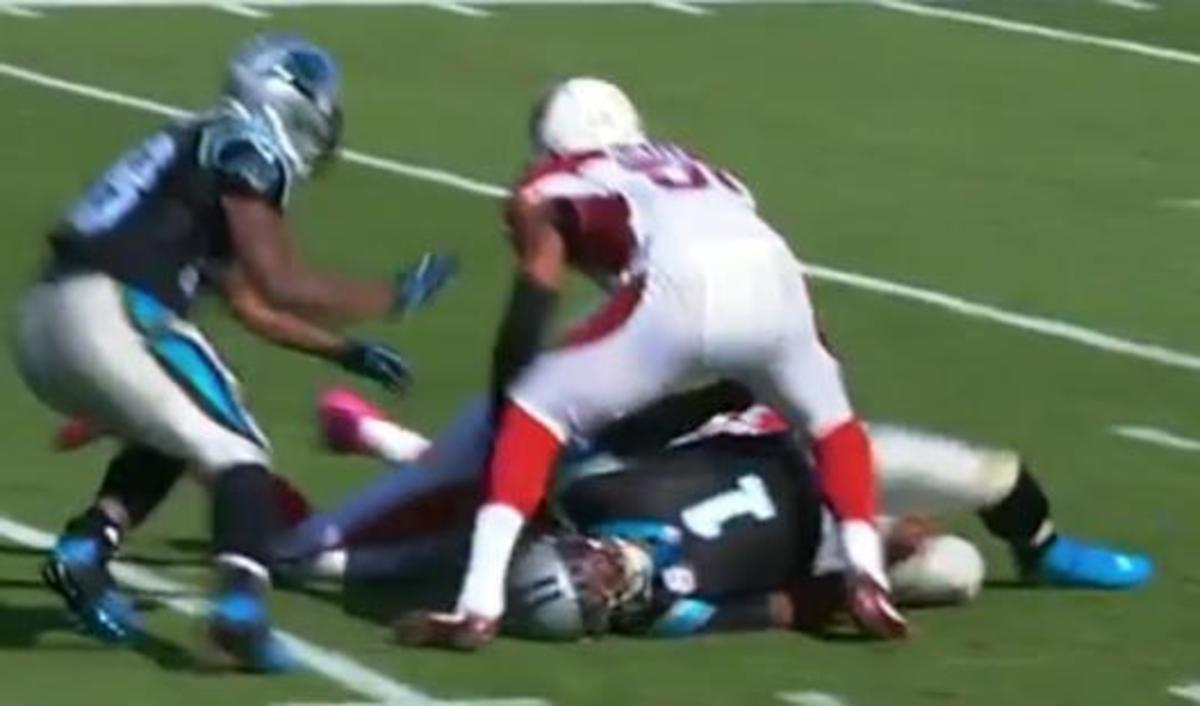 Cam Newton on the ground after being hit by Arizona's defender.