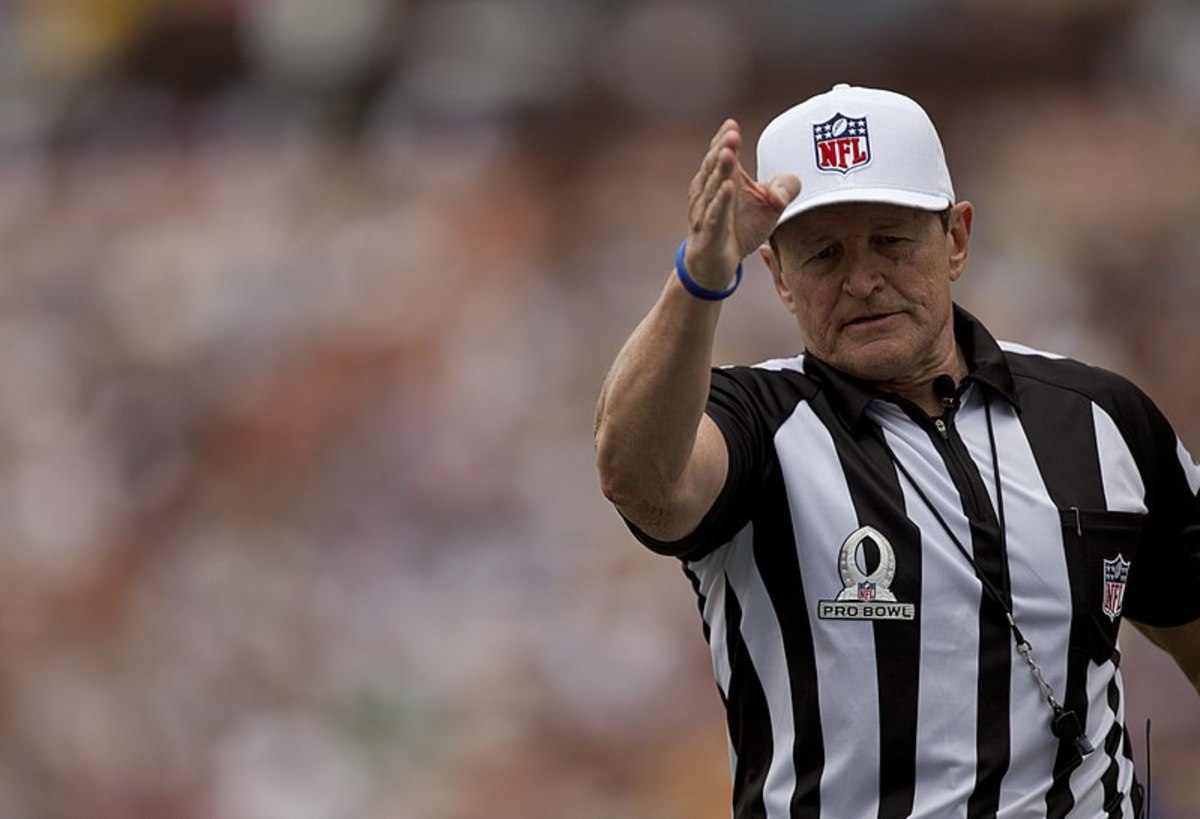 Legendary NFL referee Ed Hochuli signals a first down.