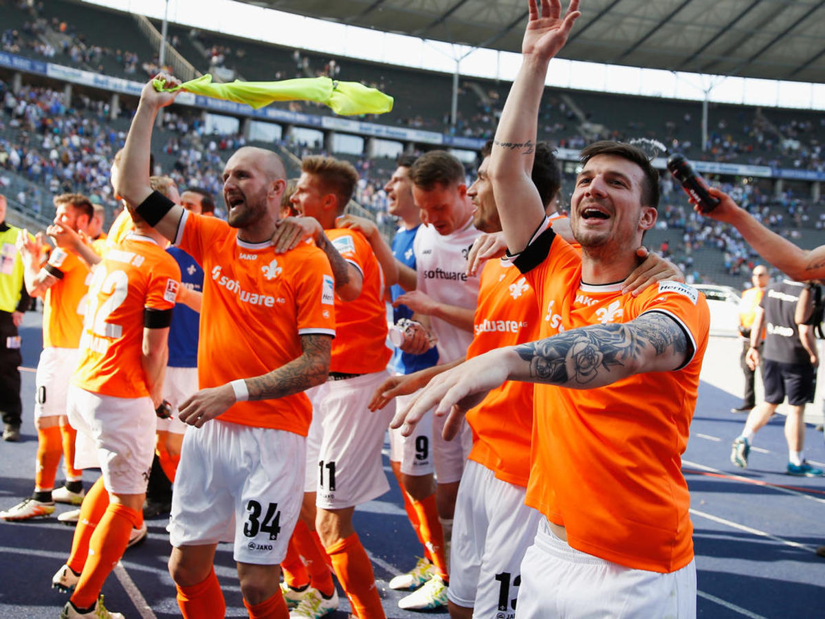 Konstantin Rausch (#34) celebrates with teammates and fans inside Berlin's Olympiastadion following a Bundesliga match on May 7, 2016. The club's 2-1 victory in the penultimate matchday secured another season in the Bundesliga with one game to spare.