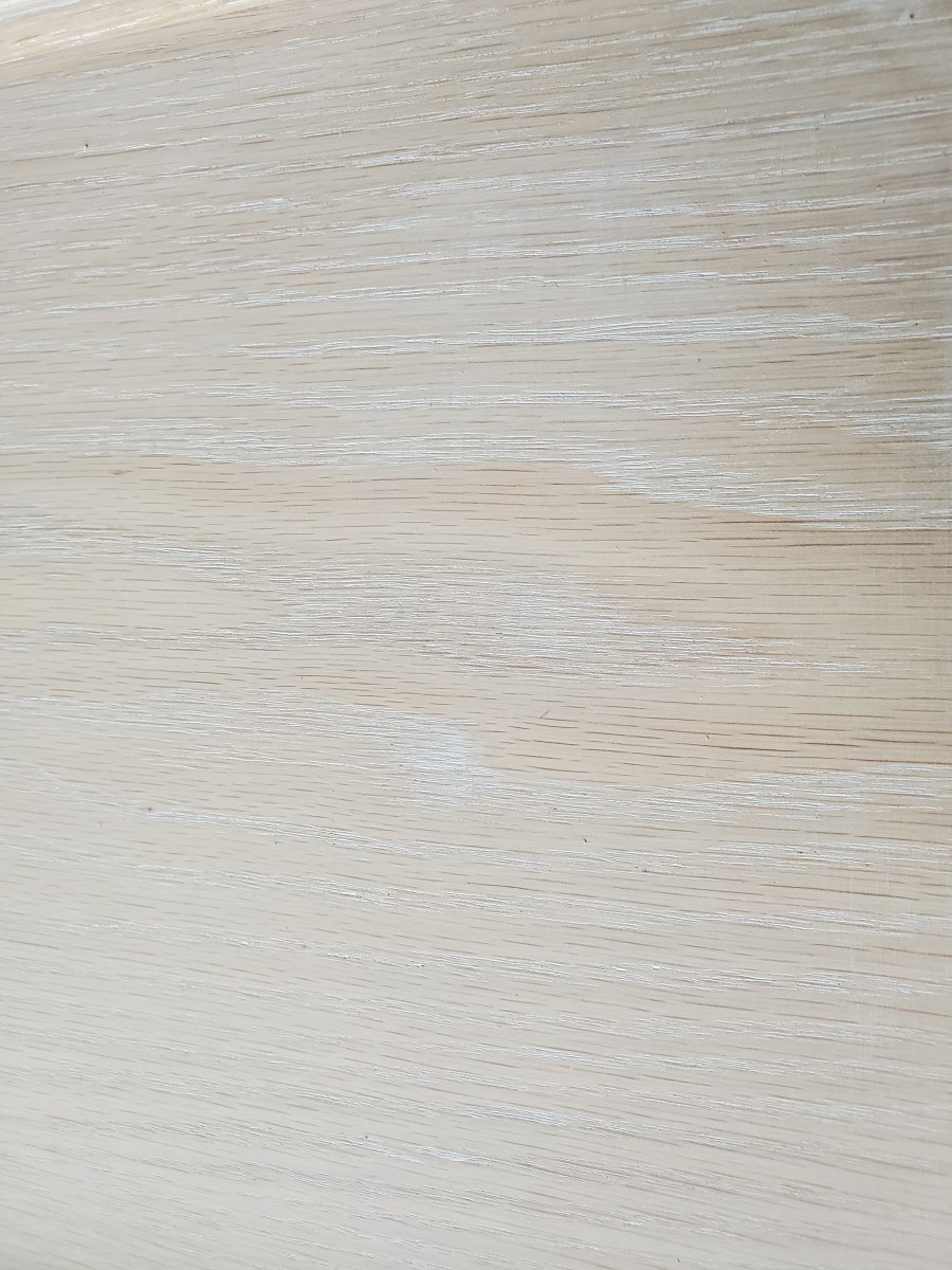 A close-up of oak I skim-coated with grain filler.