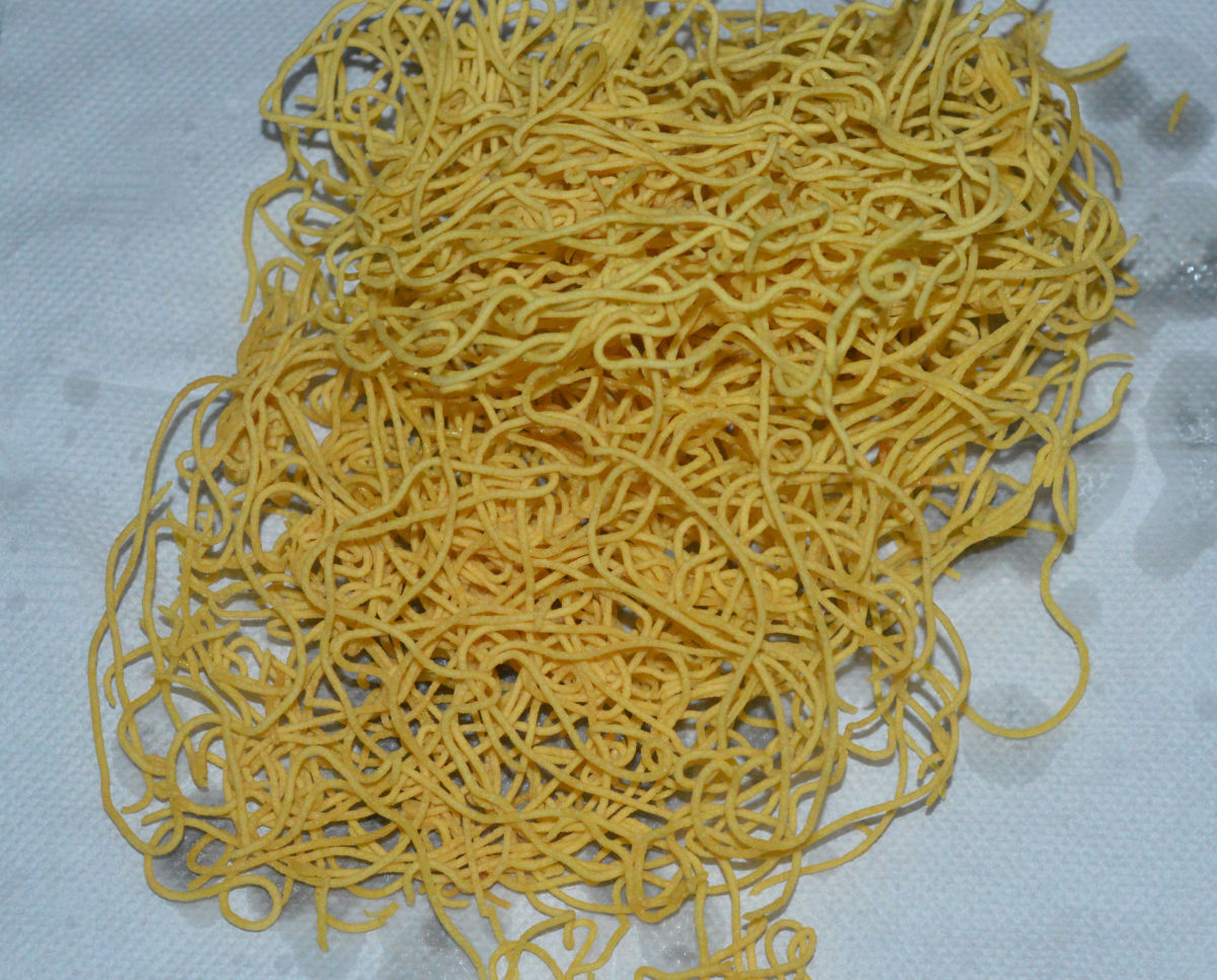 Gently, flip the se. Thin sev cooks faster. Transfer them from the oil when they become crunchy. Place them on an absorbent paper. Repeat the same with the remaining dough. Once the sev cools, break them with your fingers to get small pieces.
