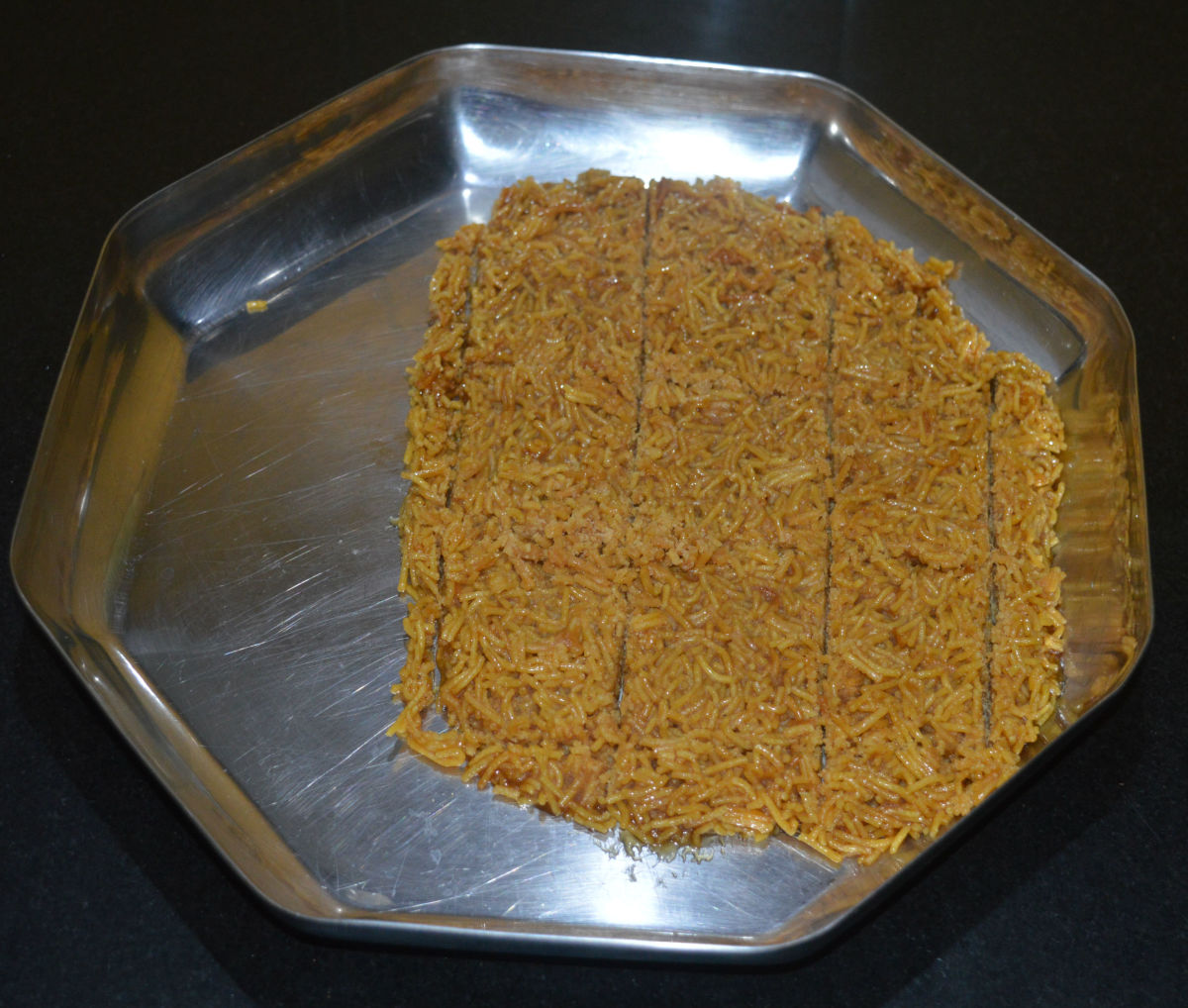 After 5 minutes, draw shallow criss-cross lines on the sev chikki, so that you can get rectangle or square pieces when you cut them on the line.