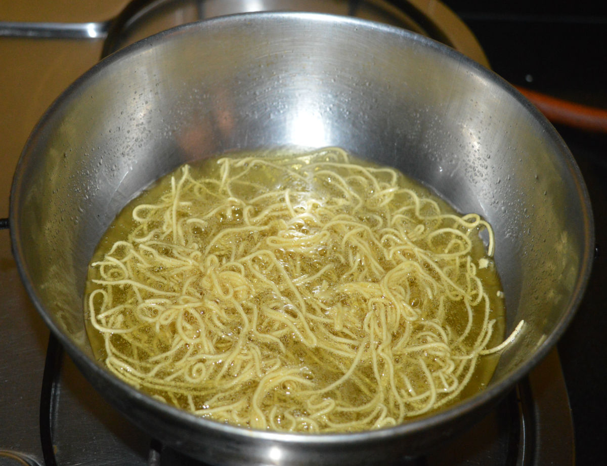 Heat the oil for deep-frying. Keep the heat at medium. Press or turn the appliance, so that raw sev comes out of the mould and falls in the oil. Don't overcrowd the sev.