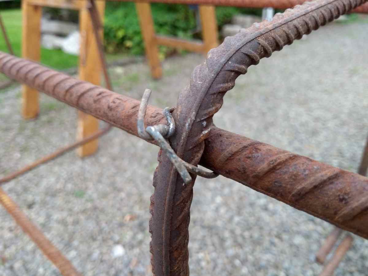 Sections of rebar are held together by steel wire, twisted together with a pliers.